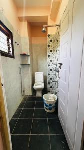 a bathroom with a toilet and a sink and a door at Lekkya service Appartment in Chikmagalūr