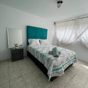 a bed with a blue headboard in a bedroom at Hermoso departamento con Patio in Apizaco