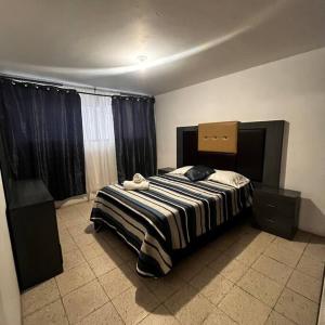 una camera con un letto con una coperta a righe di Hermoso departamento con Patio ad Apizaco