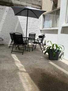 a patio with a table and chairs and an umbrella at Hermoso departamento con Patio in Apizaco