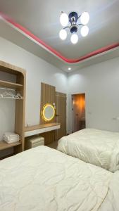 - une chambre avec 2 lits et un ventilateur de plafond dans l'établissement Grand Pool Villa Khonkaen เขื่อนอุบลรัตน์, 