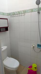 a bathroom with a toilet and a shower at Hotel GRAND NEW SIJAGO in Wanasari