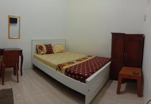 a small bedroom with a bed and a table at Hotel GRAND NEW SIJAGO in Wanasari