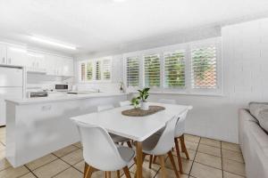 a kitchen and dining room with a white table and chairs at Riverview Two Apartments in Mooloolaba