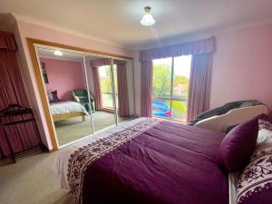 um quarto com uma grande cama roxa e uma janela em Oscars Retreat em Kingston