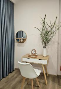 einen Schreibtisch mit einem weißen Stuhl und einem Spiegel in der Unterkunft Anna House Homestay in Kim Quan