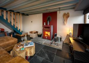 a living room with a fireplace and a couch at Cysgu Llwynog in Llannor