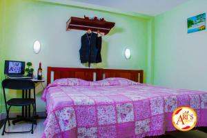 a bedroom with a bed with a pink blanket at ALLISON HOTEL in Iquitos