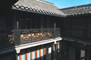 un bâtiment avec une clôture sur son côté dans l'établissement Glaze Garden Hotel, à Yangzhou