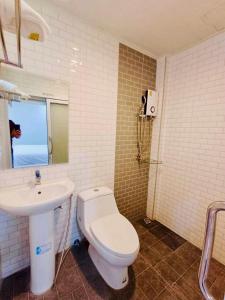ein Bad mit einem WC und einem Waschbecken in der Unterkunft โรงแรมเอ็น.เจ. ธาตุพนม 