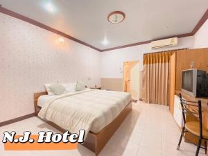 ein Hotelzimmer mit einem Bett und einem TV in der Unterkunft โรงแรมเอ็น.เจ. ธาตุพนม 