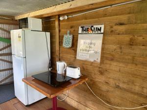 einen Kühlschrank und einen Tisch im Zimmer in der Unterkunft Casa Tavaita in Karangahake gorge in Paeroa