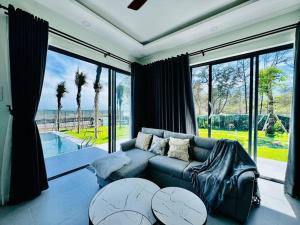 a living room with a couch and a large window at Whispering waves beachfront villa in Tiến Thành