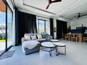 a living room with a couch and two tables at Whispering waves beachfront villa in Tiến Thành