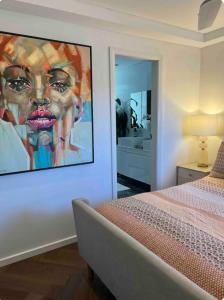 een slaapkamer met een groot schilderij aan de muur bij Chic Rose Bay Pad with HUGE outdoor sunny balcony in Sydney