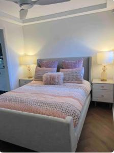 een slaapkamer met een bed met kussens en 2 lampen bij Chic Rose Bay Pad with HUGE outdoor sunny balcony in Sydney