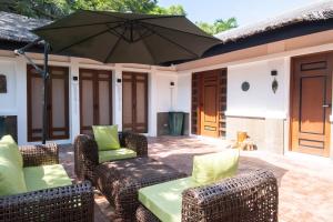 a patio with two chairs and an umbrella at NAWA Wellness in Calatagan