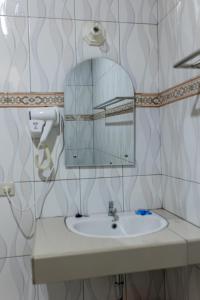 La salle de bains est pourvue d'un lavabo et d'un miroir. dans l'établissement Gokhon Guest House, à Tuk Tuk