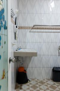a bathroom with a sink and a tiled wall at Gokhon Guest House in Tuktuk Siadong