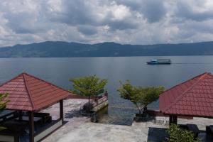 widok na jezioro z łodzią w wodzie w obiekcie Gokhon Guest House w mieście Tuktuk