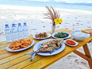 a table with plates of food and bottles of water at Lihaga Island & Beach Club in Serai