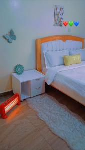 um quarto com uma cama e uma mesa de cabeceira ao lado em GP homes em Nyeri