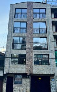 a tall brick building with many windows at Aparta Suite Torre De Prado 503 in Medellín