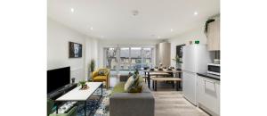 a living room with a kitchen and a dining room at A Splash of Color: Spacious & Funky 3-BR Flat in London