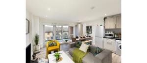 un soggiorno con divano e una cucina di A Splash of Color: Spacious & Funky 3-BR Flat a Londra