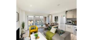 a living room with a couch and a kitchen at A Splash of Color: Spacious & Funky 3-BR Flat in London