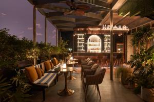 a patio with tables and chairs and a building at The Ann Hanoi Hotel & Spa in Hanoi