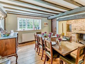 a dining room with a wooden table and a fireplace at 4 Bed in Icklesham BT067 in Icklesham