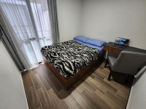 ein kleines Schlafzimmer mit einem Bett und einem Schreibtisch mit einem Laptop in der Unterkunft Habitacion en Departamento Compartido in Mexiko-Stadt