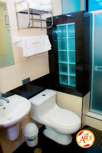een badkamer met een toilet, een wastafel en een douche bij ALLISON HOTEL in Iquitos