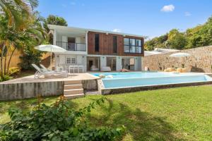 a villa with a swimming pool and a house at Villa Alexina in Le Robert