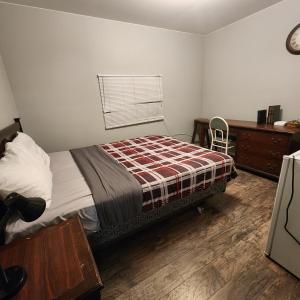 1 dormitorio con cama, escritorio y ventana en Earthquest Lodge en Port Burwell
