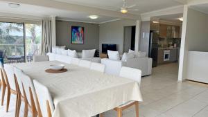 comedor con mesa blanca y sillas blancas en Cunninghame Views, en Lakes Entrance