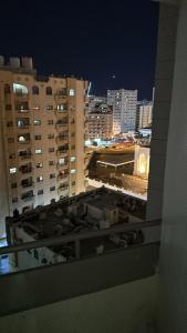 a view of a city at night from a window at El Mahatta Building in Sharjah