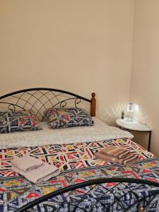 een bed met een dekbed en kussens erop bij Apartment Seifullina473 in Alma-Ata