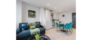 a living room with a blue couch and a table at Harmonious Greens: Cozy 1-Bed Flat in Harrow in Harrow
