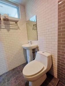 ein Badezimmer mit einem weißen WC und einem Waschbecken in der Unterkunft โรงแรมเอ็น.เจ. ธาตุพนม 