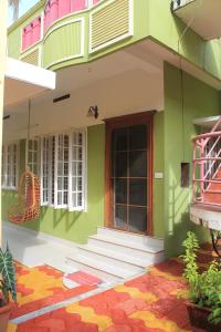 a green building with stairs and a door at Oshin Home Stay in Cochin