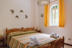 ein Schlafzimmer mit einem Bett und einem Fenster mit Fledermäusen an der Wand in der Unterkunft Portysud in Lipari