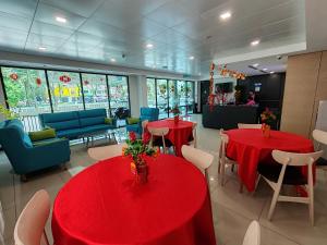 a restaurant with red tables and chairs in a room at SRITEL BOUTIQUE HOTEL in Shah Alam