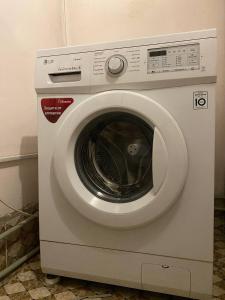 a white washing machine sitting in a room at Sunny Guest House in Osh