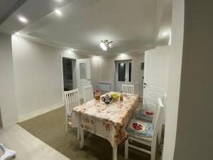 a white dining room with a table and chairs at Sunny Guest House in Osh