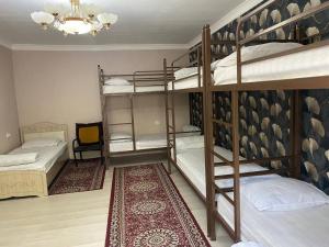 a room with three bunk beds and a chandelier at Sunny Guest House in Osh