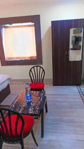 ブバネーシュワルにあるVENTURE INNのテーブルと椅子2脚、ドアが備わる部屋