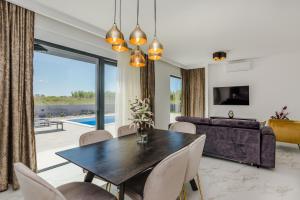 een eetkamer met een tafel en een bank bij Villa Anabel in Privlaka