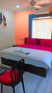 1 dormitorio con 1 cama grande y 1 silla en VENTURE INN, en Bhubaneshwar